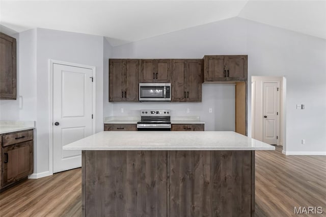 943 Stone Gate Dr, De Soto, MO 63020 - kitchen featuring appliances with stainless steel finishes, light wood-style flooring, baseboards, vaulted ceiling, and light countertops