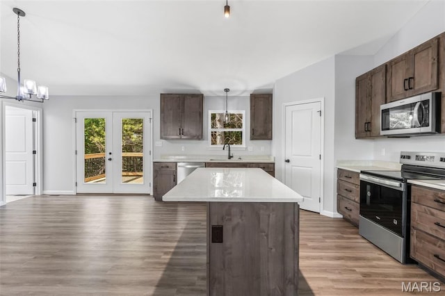943 Stone Gate Dr, De Soto, MO 63020 - kitchen featuring stainless steel appliances, a sink, a chandelier, light wood-style flooring, and light countertops
