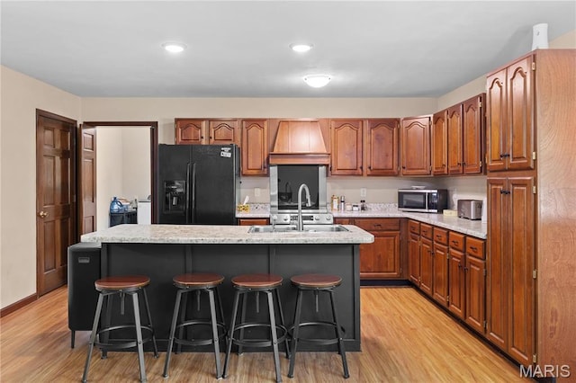 511 Ruddy Ct, Troy, IL 62294 - kitchen with black refrigerator with ice dispenser, stainless steel microwave, custom range hood, a sink, and light wood-type flooring