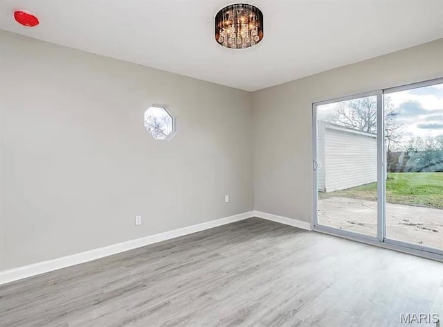 5108 S Gem Dr, High Ridge, MO 63049 - spare room featuring wood finished floors and a chandelier