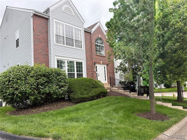 view of front of house with a front lawn and brick siding