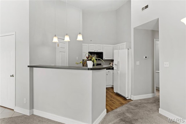 84 Timber Creek Dr Unit 8D, Ofallon, MO 63368 - kitchen with white refrigerator with ice dispenser, high vaulted ceiling, dark countertops, white cabinetry, and carpet floors