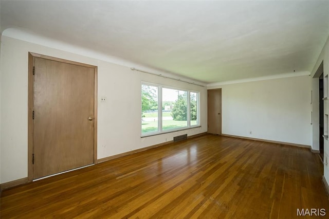 unfurnished room with wood-type flooring and baseboards