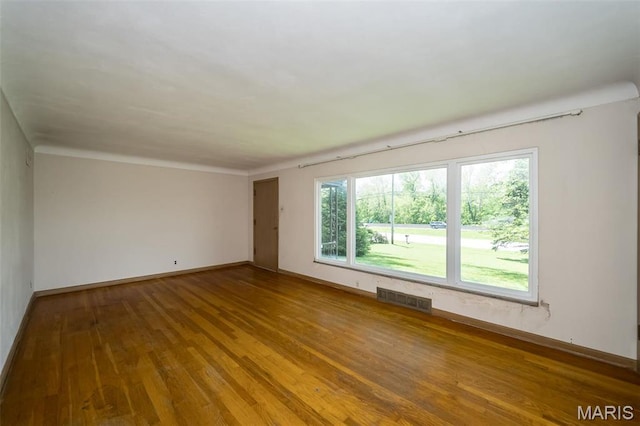 empty room with hardwood / wood-style floors and baseboards