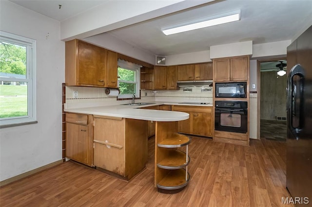 kitchen featuring black appliances, open shelves, a sink, and brown cabinetry