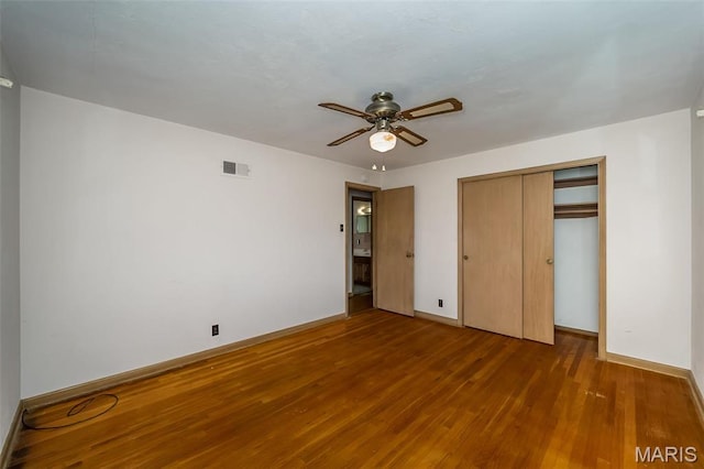 unfurnished bedroom with wood finished floors, baseboards, a closet, and ceiling fan
