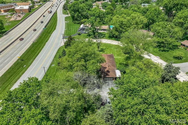 aerial view of property's location featuring a major roadway and a tree filled landscape