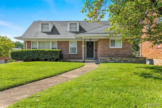 7114 Clayton Rd, Saint Louis, MO 63117 - view of front facade with a front yard, brick siding, and a shingled roof