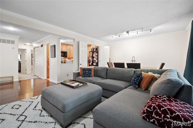 5567 Waterman Blvd Unit D, Saint Louis, MO 63112 - living room featuring crown molding, wood finished floors, baseboards, and a textured ceiling