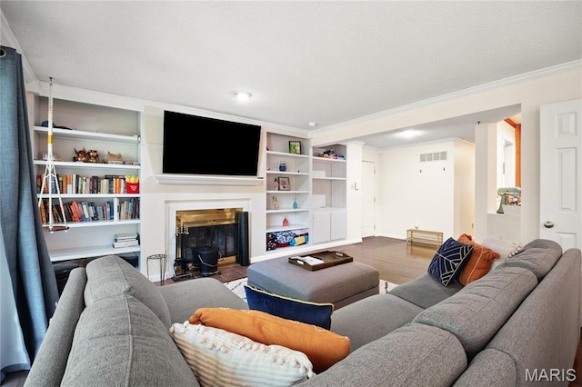 5567 Waterman Blvd Unit D, Saint Louis, MO 63112 - living room with wood finished floors, ornamental molding, a glass covered fireplace, baseboards, and built in shelves
