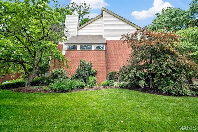 5567 Waterman Blvd Unit D, Saint Louis, MO 63112 - view of property exterior featuring a chimney, a yard, and brick siding