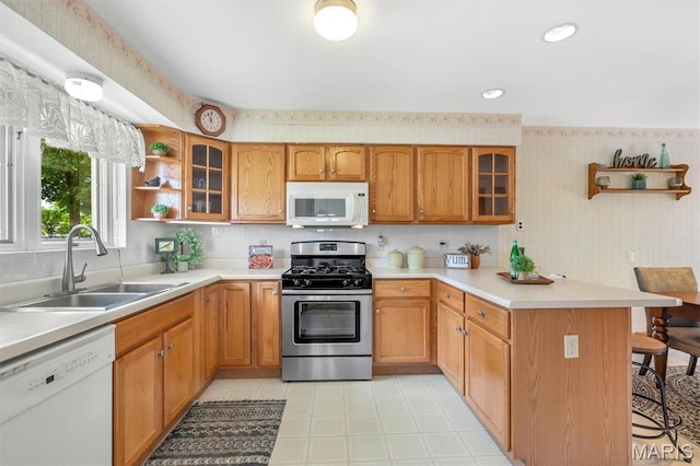 10710 Winthrop Ct, Saint Louis, MO 63123 - kitchen featuring white appliances, a peninsula, a kitchen bar, open shelves, and light countertops