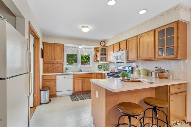 10710 Winthrop Ct, Saint Louis, MO 63123 - kitchen with white appliances, a peninsula, light countertops, glass insert cabinets, and light flooring
