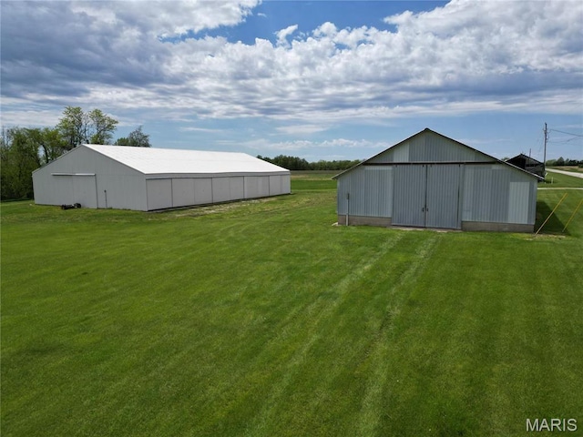 view of green lawn featuring an outbuilding