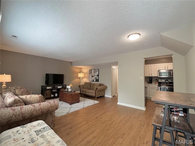 9169 N Swan Cir, Brentwood, MO 63144 - living area with light wood-type flooring, a textured ceiling, and baseboards