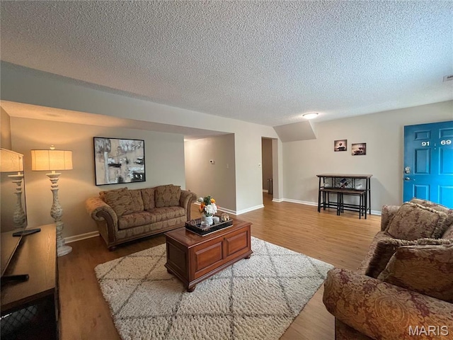 9169 N Swan Cir, Brentwood, MO 63144 - living area with wood finished floors, a textured ceiling, and baseboards