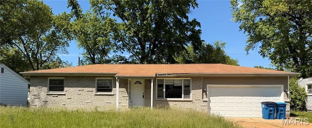 ranch-style house featuring an attached garage, brick siding, and driveway