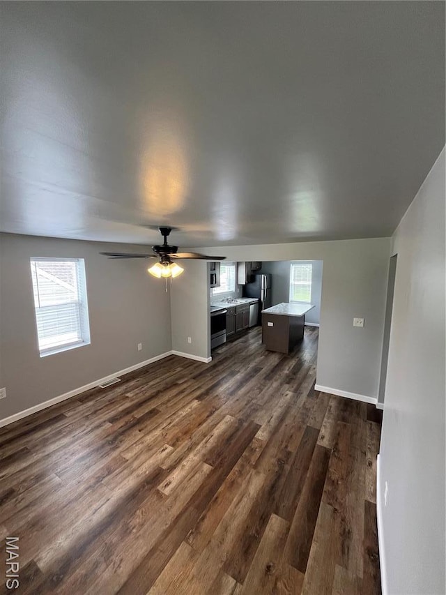 721 Woodland Ave, Festus, MO 63028 - unfurnished living room with dark wood finished floors, baseboards, and a ceiling fan