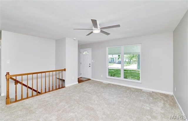 carpeted empty room with baseboards and ceiling fan