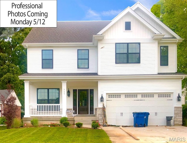 view of front of house featuring a porch, driveway, a front lawn, an attached garage, and roof with shingles