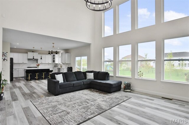 112 Westhaven View Dr, Wentzville, MO 63385 - living area featuring a chandelier, light wood-style flooring, a high ceiling, and baseboards