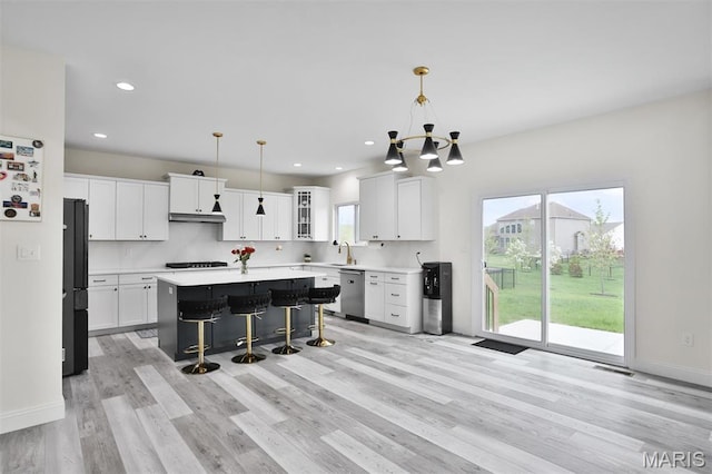 112 Westhaven View Dr, Wentzville, MO 63385 - kitchen with dishwasher, a chandelier, a kitchen breakfast bar, light wood-type flooring, and a kitchen island
