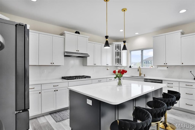 112 Westhaven View Dr, Wentzville, MO 63385 - kitchen featuring freestanding refrigerator, a sink, gas cooktop, light wood-style floors, and a kitchen breakfast bar