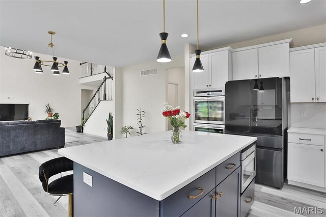 112 Westhaven View Dr, Wentzville, MO 63385 - kitchen featuring stainless steel appliances, open floor plan, white cabinets, light wood-type flooring, and recessed lighting