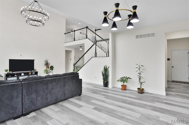 112 Westhaven View Dr, Wentzville, MO 63385 - living room with a chandelier, wood finished floors, stairway, and a towering ceiling