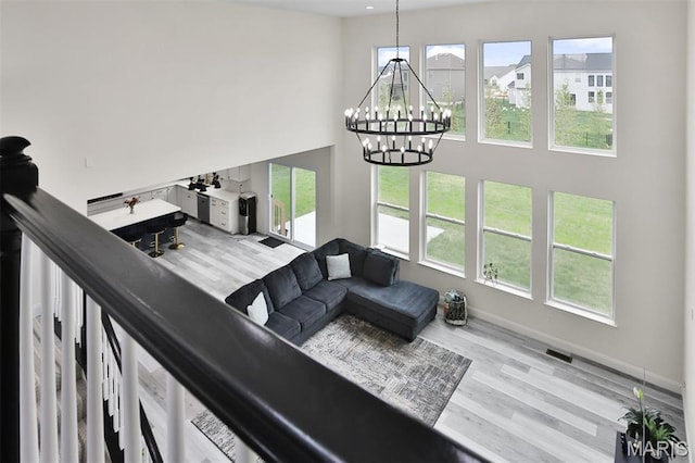 112 Westhaven View Dr, Wentzville, MO 63385 - living room with a high ceiling, a chandelier, wood finished floors, and healthy amount of natural light
