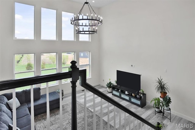 112 Westhaven View Dr, Wentzville, MO 63385 - living area with a chandelier, wood finished floors, baseboards, and a towering ceiling
