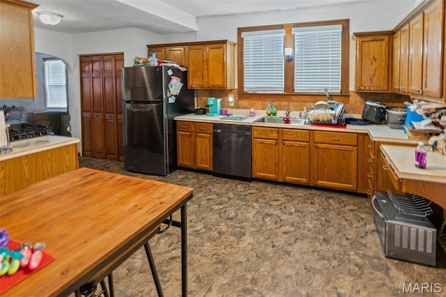 113 Orchard Dr, Belleville, IL 62221 - kitchen featuring black dishwasher, freestanding refrigerator, brown cabinetry, a sink, and light countertops