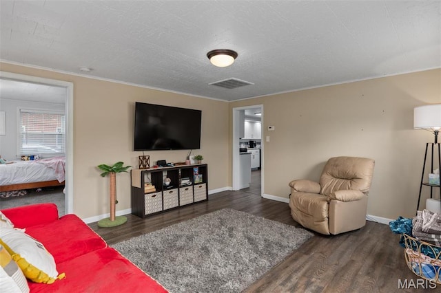 living room featuring wood finished floors, ornamental molding, and baseboards