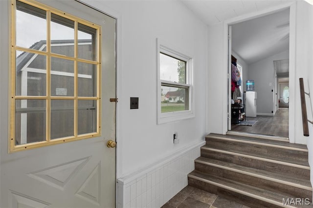 doorway to outside with vaulted ceiling and stairs