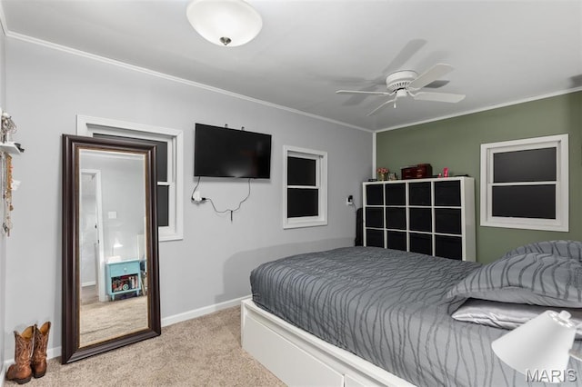 bedroom with light colored carpet, ornamental molding, baseboards, and a ceiling fan