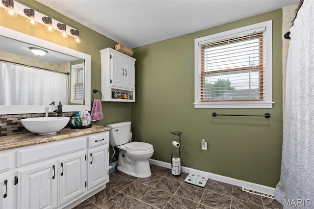 full bathroom featuring baseboards, toilet, and vanity