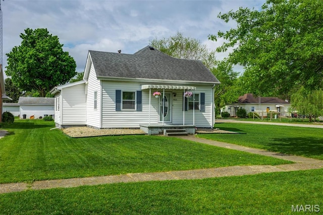 view of front of property with a front yard and a shingled roof