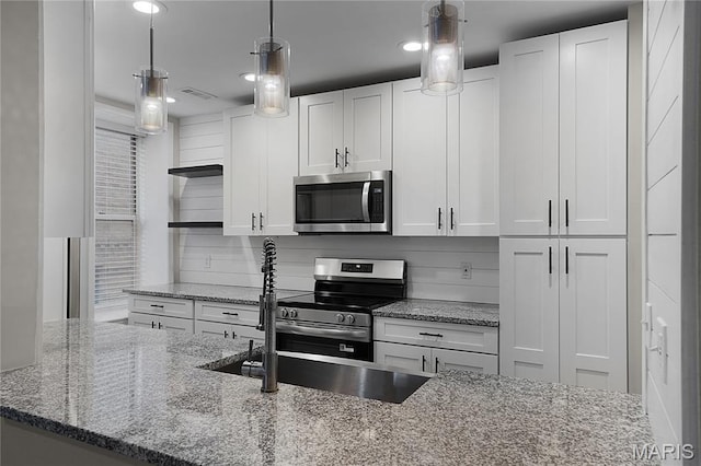 4250 Lindell Blvd Unit A, Saint Louis, MO 63108 - kitchen featuring appliances with stainless steel finishes, white cabinets, stone counters, decorative backsplash, and decorative light fixtures