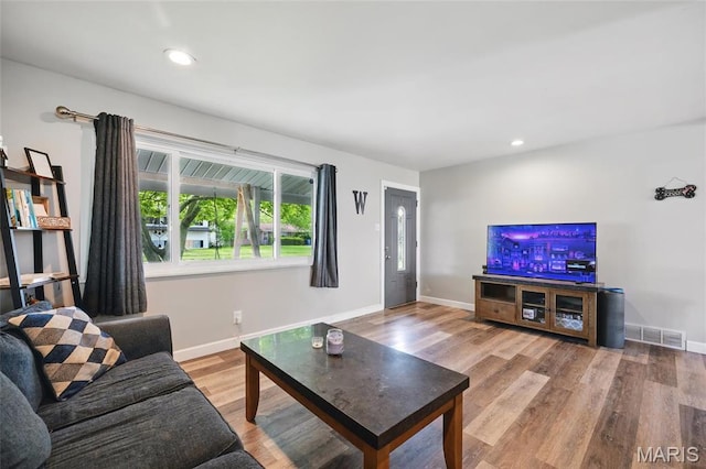 living room with baseboards, wood finished floors, and recessed lighting