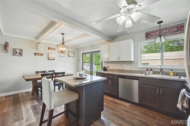 kitchen with stainless steel dishwasher, a sink, beamed ceiling, a kitchen breakfast bar, and dark wood finished floors