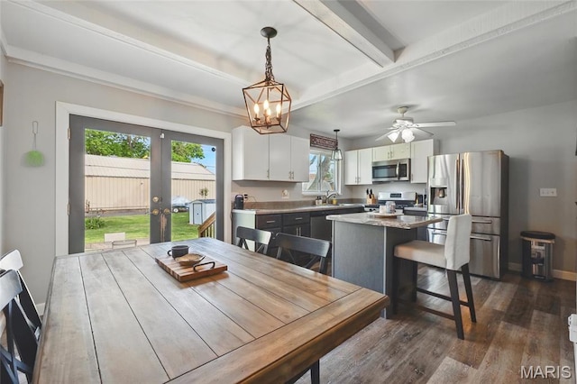 dining room featuring french doors, dark wood finished floors, beamed ceiling, a chandelier, and baseboards