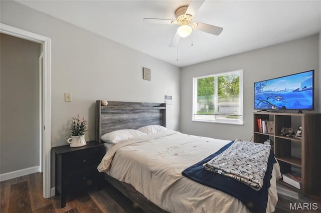 bedroom with wood finished floors, a ceiling fan, and baseboards