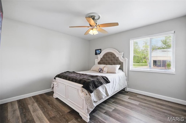 bedroom featuring baseboards, dark wood finished floors, and a ceiling fan