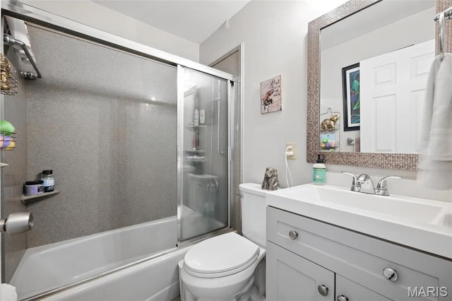 bathroom featuring toilet, enclosed tub / shower combo, and vanity