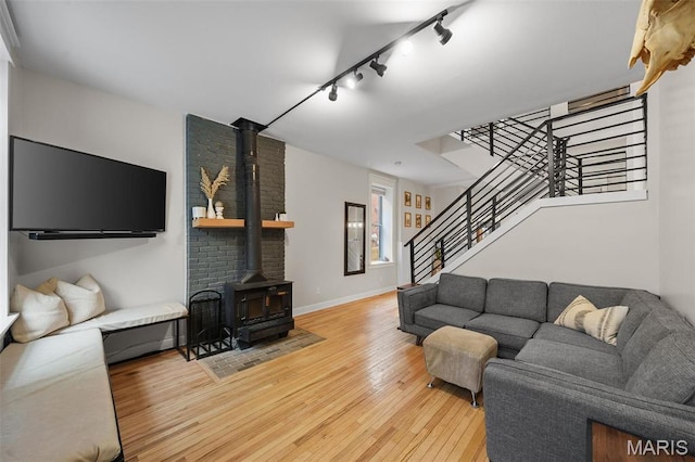 2005 Arsenal St, Saint Louis, MO 63118 - living room with a wood stove, hardwood / wood-style flooring, track lighting, stairway, and baseboards