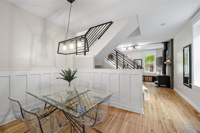 2005 Arsenal St, Saint Louis, MO 63118 - dining space with stairs, light wood-style floors, a wainscoted wall, and a decorative wall