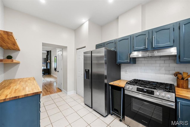 2005 Arsenal St, Saint Louis, MO 63118 - kitchen featuring stainless steel appliances, wooden counters, under cabinet range hood, blue cabinetry, and open shelves