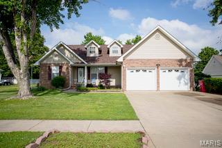 1014 Pine St, Sikeston, MO 63801 - view of front of house featuring an attached garage, driveway, and a front lawn