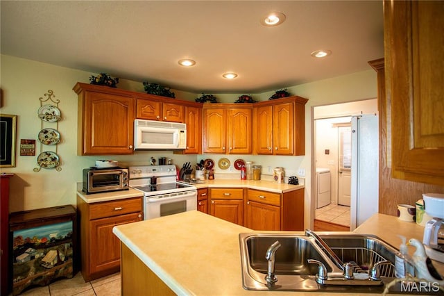 1014 Pine St, Sikeston, MO 63801 - kitchen featuring white appliances, a sink, light tile patterned floors, washer / clothes dryer, and light countertops