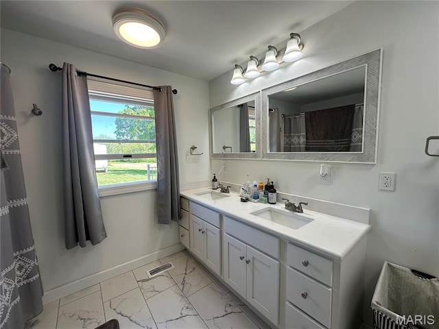 17260 Carver Dr, New London, MO 63459 - bathroom featuring marble look tiles, double vanity, and baseboards